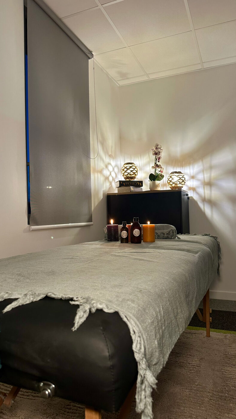 Le cabinet : table de massage, bougies et huiles